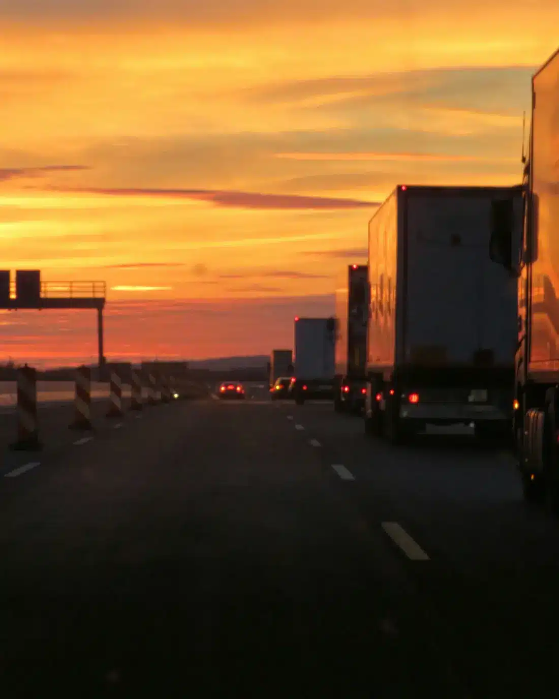 Camiones circulando por una autopista al atardecer